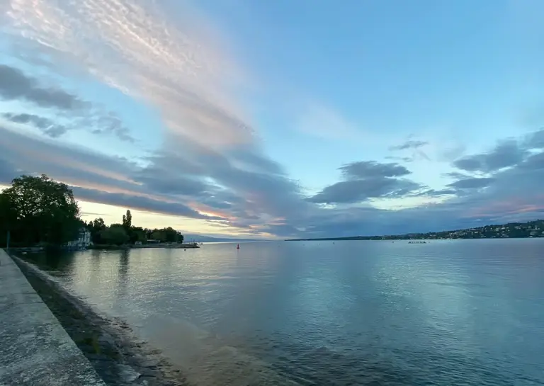 unset over Lake Geneva with calm waters and dramatic sky - beautiful Geneva lakeside where Translations Geneva is based